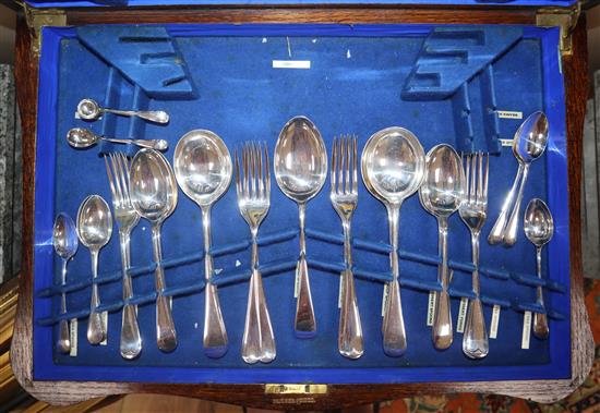 A silver plated part canteen in oak table case